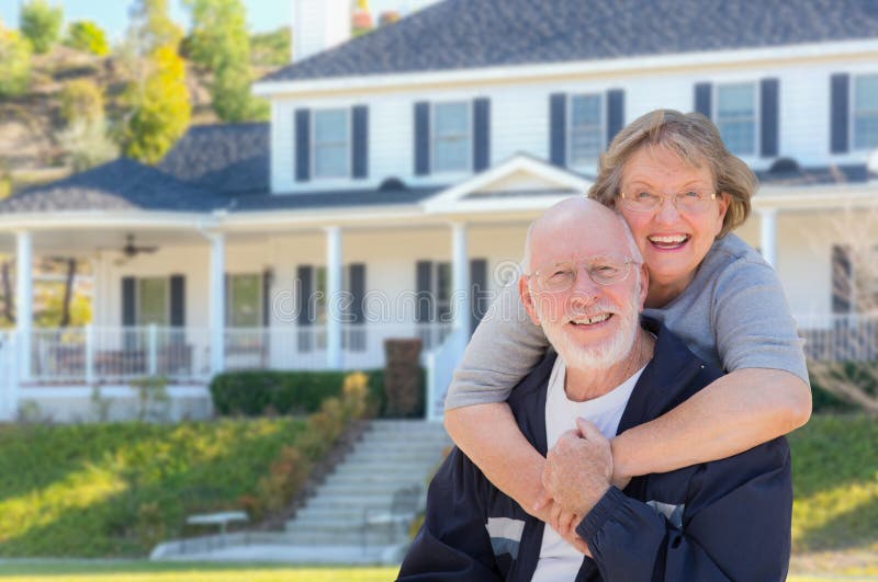 Attractive Happy Senior Couple in Front Yard of House. Attractive Happy Senior Couple in Front Yard of House.