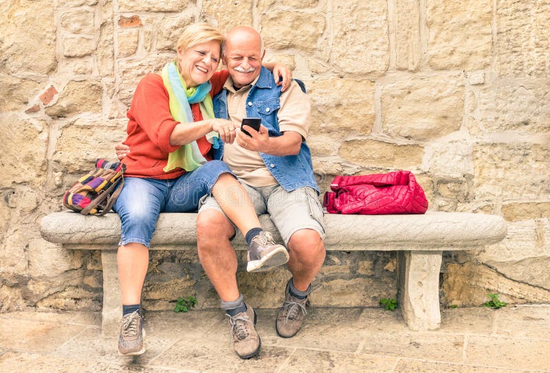 Happy senior couple having fun together with mobile smart phone stock image Happy senior couple having fun together with mobile smart phone stock image