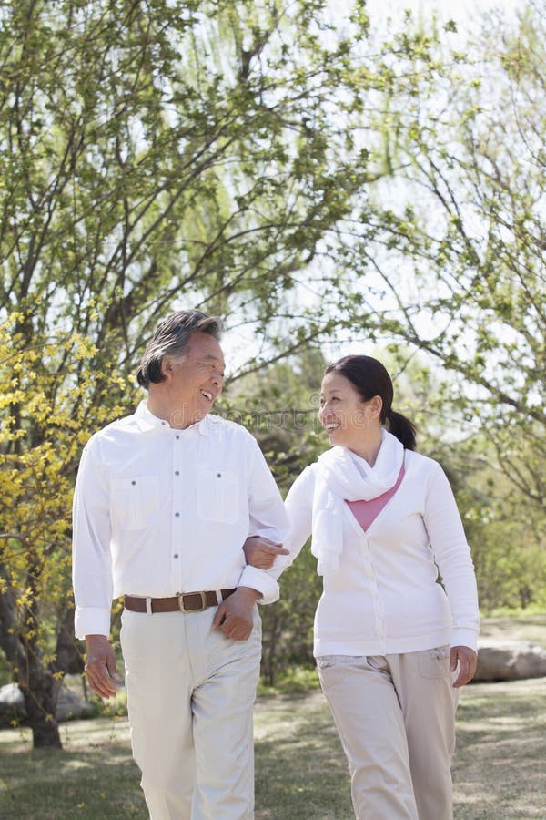 Happy senior couple holding hands and going for a walk in the park in springtime, Beijing royalty free stock photo Happy senior couple holding hands and going for a walk in the park in springtime, Beijing royalty free stock photo