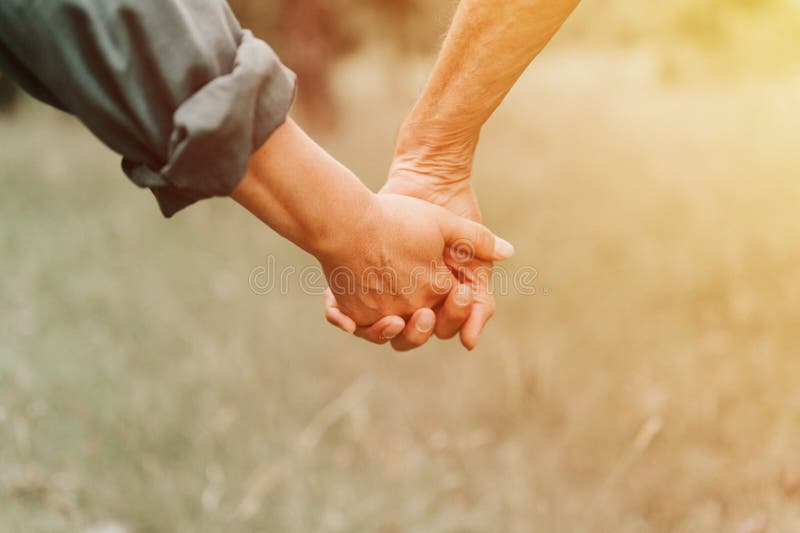 happy senior couple holding hands. hands of man and woman hold each other. romance and love and support in elderly family. faceles