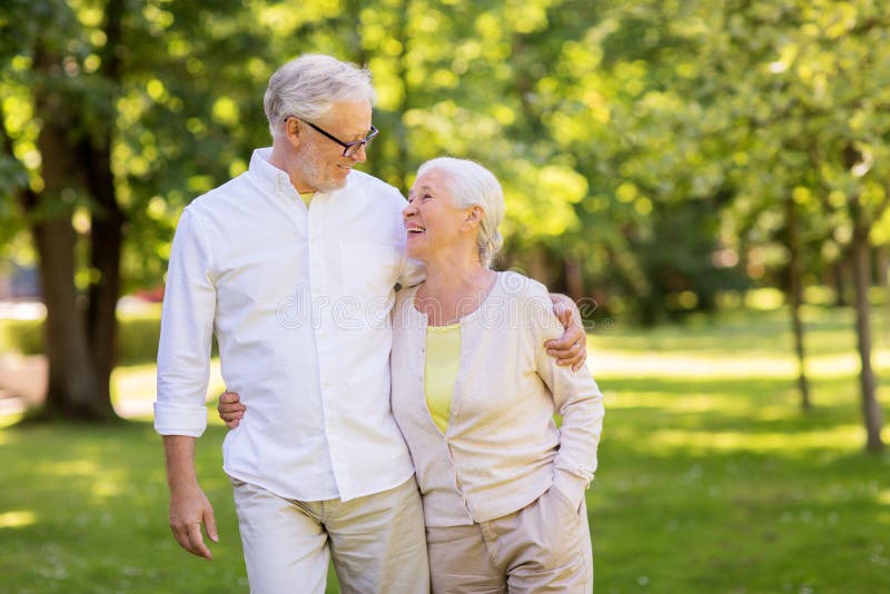 Happy senior couple hugging at summer park.