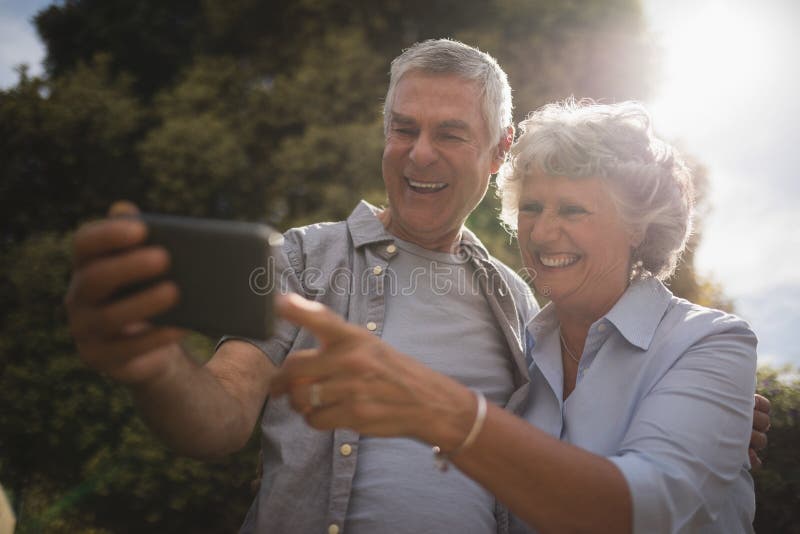 Happy senior couple looking at mobile phone stock photos Happy senior couple looking at mobile phone stock photos