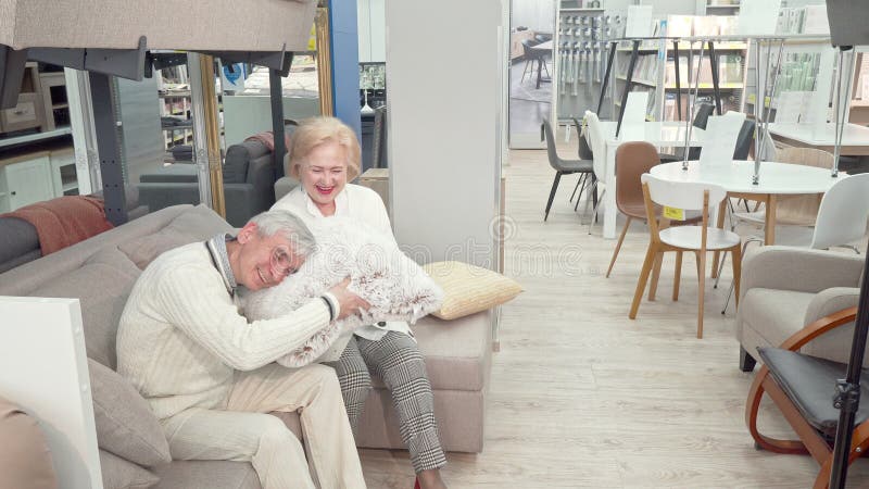 Happy senior couple shopping for furniture and cushions at department store royalty free stock image Happy senior couple shopping for furniture and cushions at department store royalty free stock image