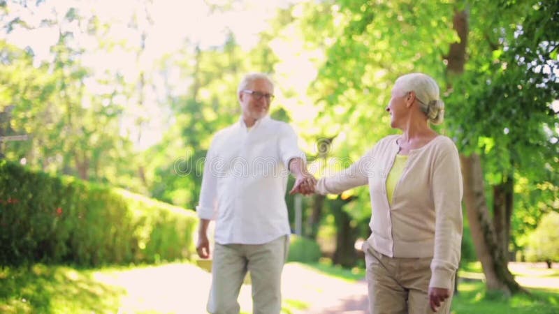 Happy senior couple walking at summer city park