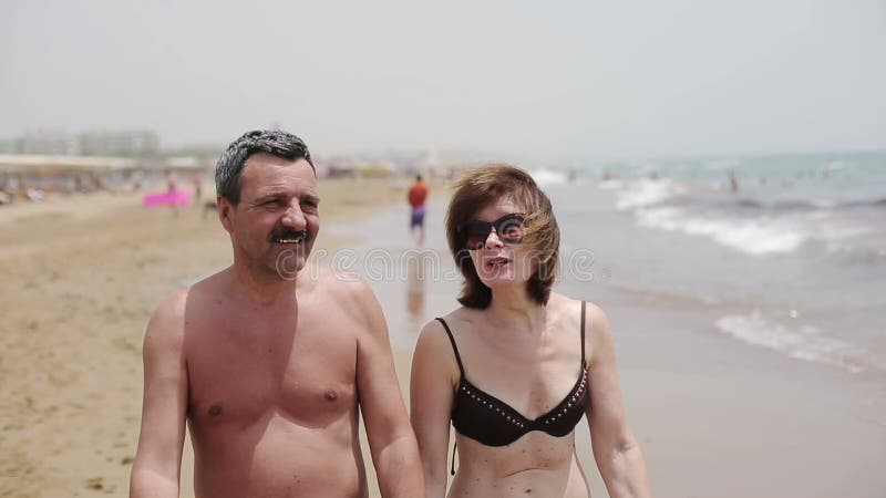 Happy senior couple walking together on a beach