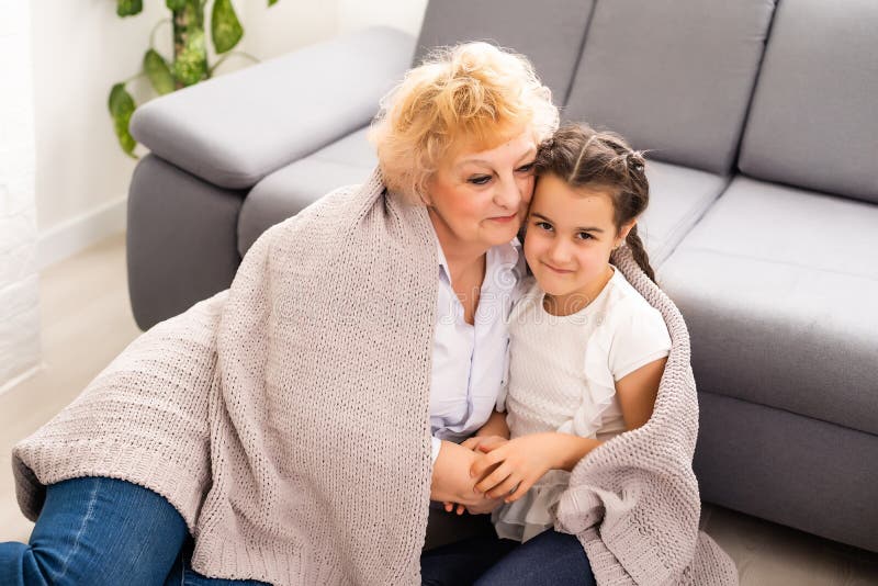 Happy Senior Grandmother Sit On Couch In Living Room Hugging Cute Little Preschooler