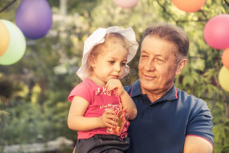 Happy senior grandparent grandchild together outdoors party park happy retirement concept