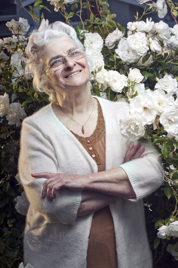 Happy senior lady in the rose garden