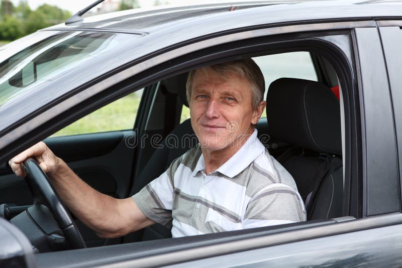 Happy senior man in car