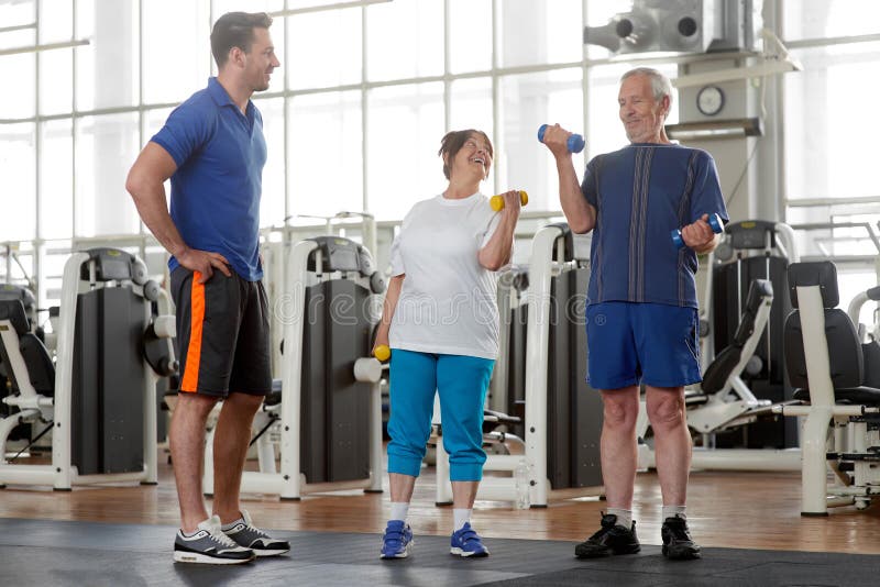 Happy Senior Sporty Couple Working Out Together At Gym Stock Photo