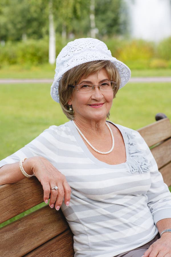 Happy senior woman sitting on a bench
