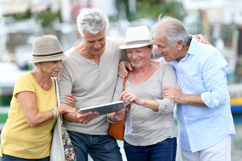Happy seniors travelling and visiting using tablet stock photo