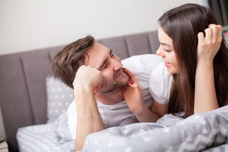 Happy sensual young couple lying in bed together. stock images Happy sensual young couple lying in bed together. stock images