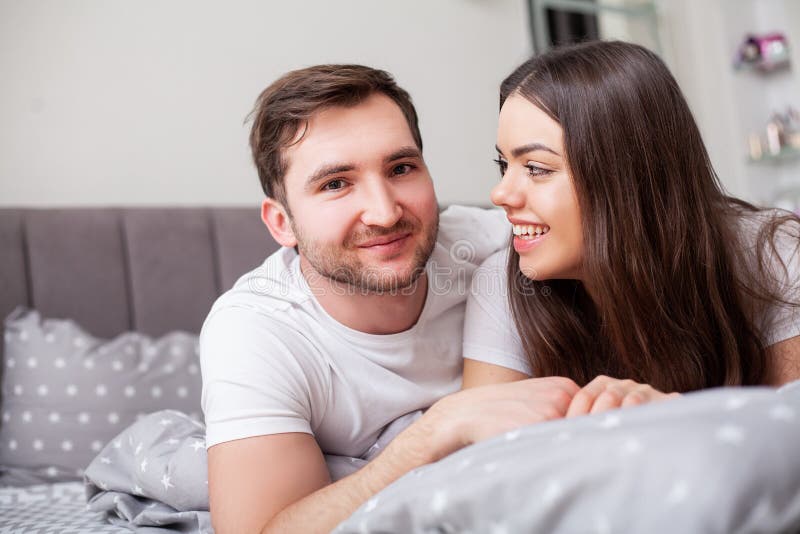 Happy sensual young couple lying in bed together. stock image Happy sensual young couple lying in bed together. stock image