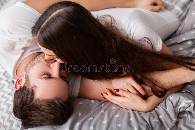 Happy sensual young couple lying in bed together. stock photo Happy sensual young couple lying in bed together. stock photo