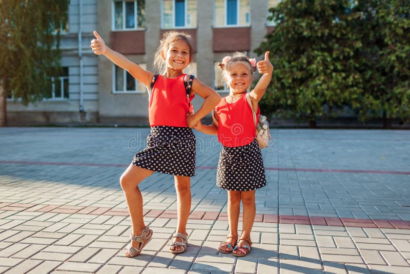 Девочки в школе показывают лайк. My sisters are pupils