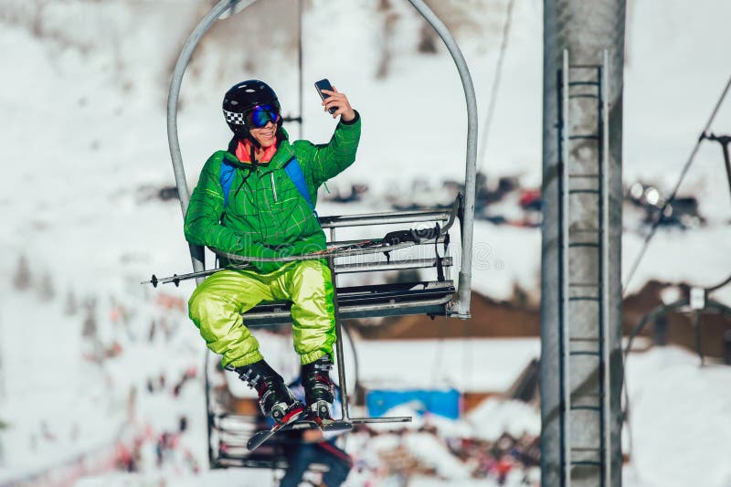 Skier taking selfie photo with smart cell phone camera sitting on ski lift royalty free stock image Skier taking selfie photo with smart cell phone camera sitting on ski lift royalty free stock image