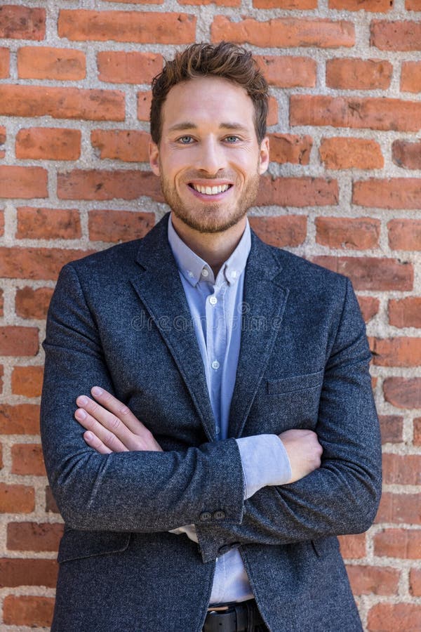 Happy smart casual businessman portrait on urban city brick wall background lifestyle portrait. Young professional man smiling royalty free stock images Happy smart casual businessman portrait on urban city brick wall background lifestyle portrait. Young professional man smiling royalty free stock images