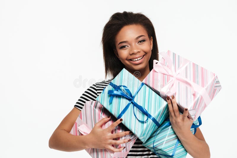 Happy smiling african woman holding stack of present boxes royalty free stock images Happy smiling african woman holding stack of present boxes royalty free stock images