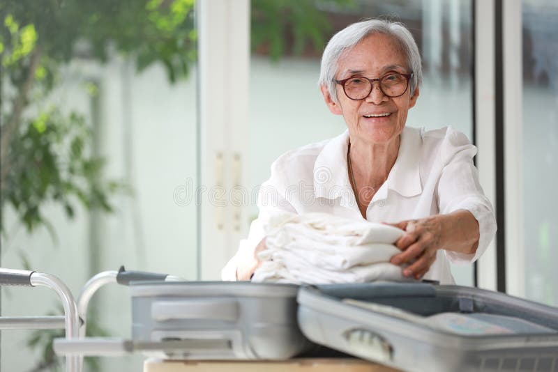 Happy Smiling Asian Senior Woman Folding Clothes In Suitcase Preparation For Journey Retired Old