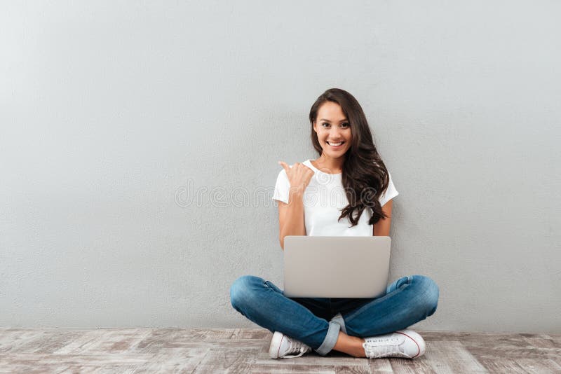 Happy smiling asian woman working on laptop computer