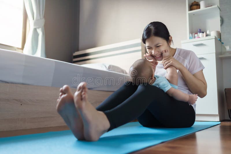 Happy Smiling Asian Young Mother in Sportswear Playing and Holding