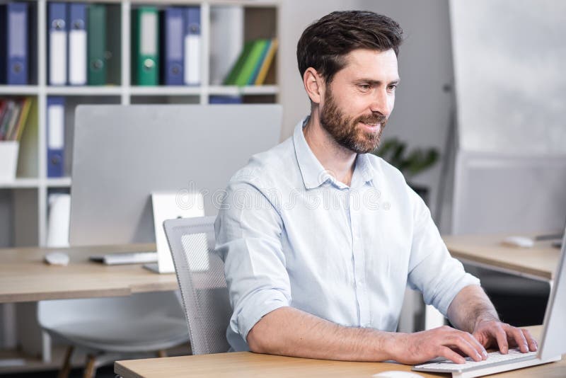 Happy and smiling businessman working in the office at the computer royalty free stock photo