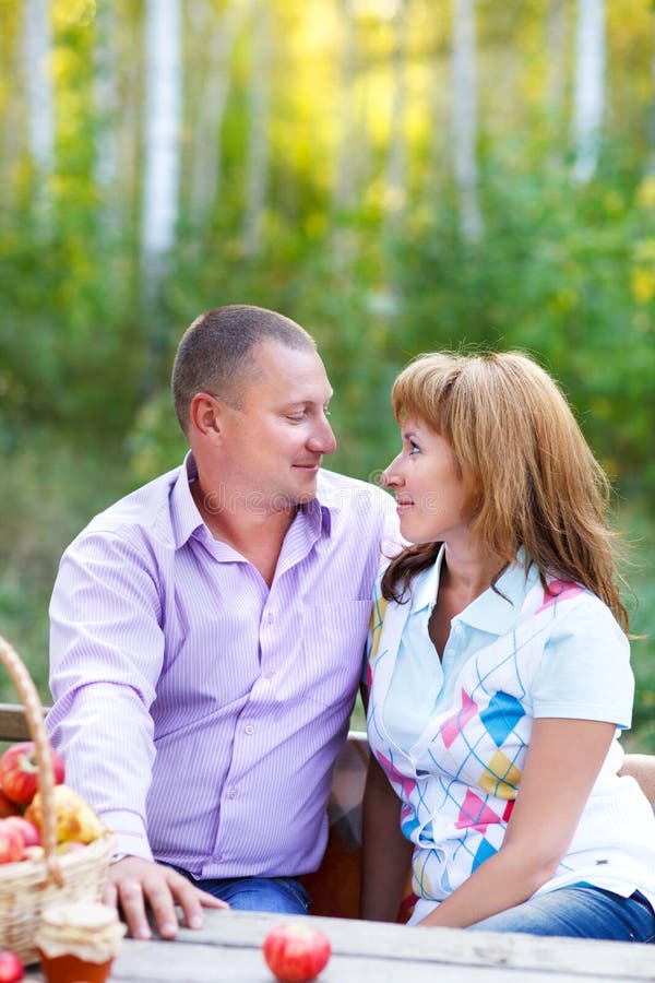 Happy smiling couple in the autumn forest on the picnic