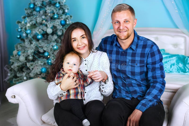 Happy smiling family near the Christmas tree. home-like atmosphere, the New Year and Christmas design