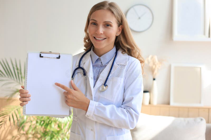 Happy smiling female doctor in white uniform coat and stethoscope royalty free stock photography