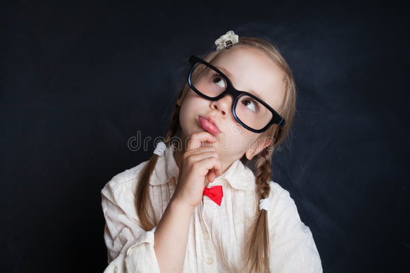 Happy smiling girl in glasses thinking and looking up royalty free stock photo Happy smiling girl in glasses thinking and looking up royalty free stock photo