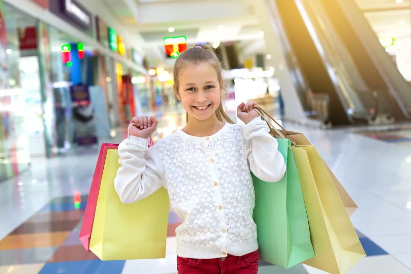 Happy smiling girl holding shopping bags in shopping center royalty free stock photo Happy smiling girl holding shopping bags in shopping center royalty free stock photo