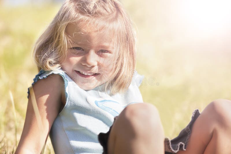 Happy smiling girl sitting in grass