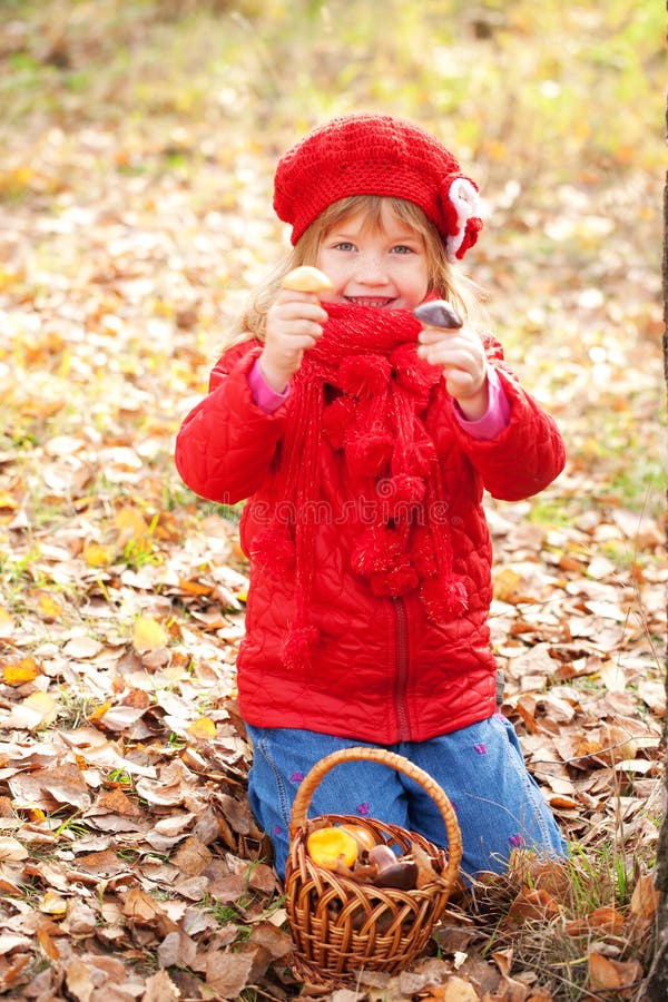 Happy smiling little girl picking mushroom