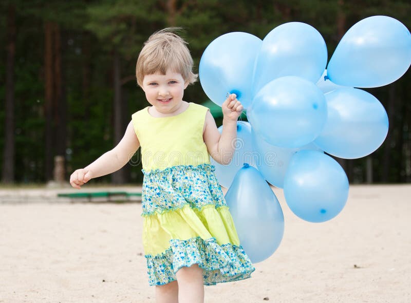Happy smiling little girl running with balloons stock image Happy smiling little girl running with balloons stock image