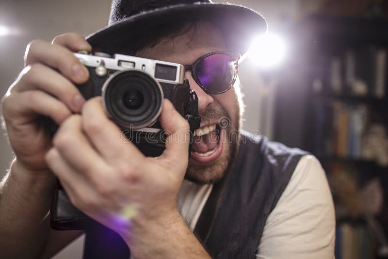 Happy smiling photographer hipster taking pictures using old sty