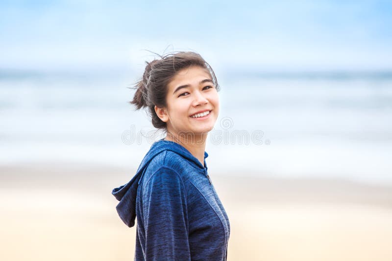 Happy, smiling teen girl in blue hoodie jacket on beach stock images Happy, smiling teen girl in blue hoodie jacket on beach stock images