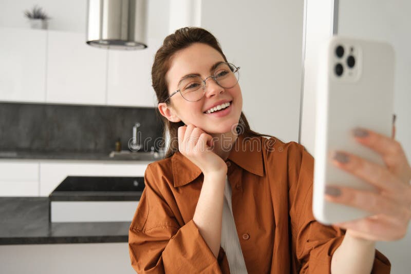 Šťastný usmívající se žena v brýle,, záznam na, chatování na mobilní telefon aplikace.