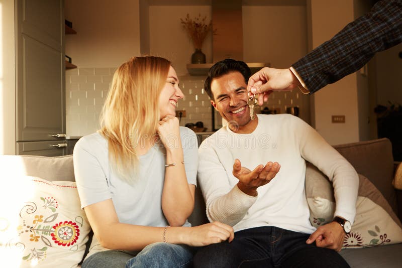Happy smiling young couple showing a keys of their new house royalty free stock photos Happy smiling young couple showing a keys of their new house royalty free stock photos
