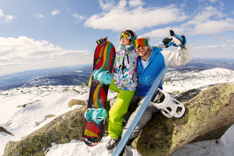 Happy snowboarding couple in winter mountains stock photos.
