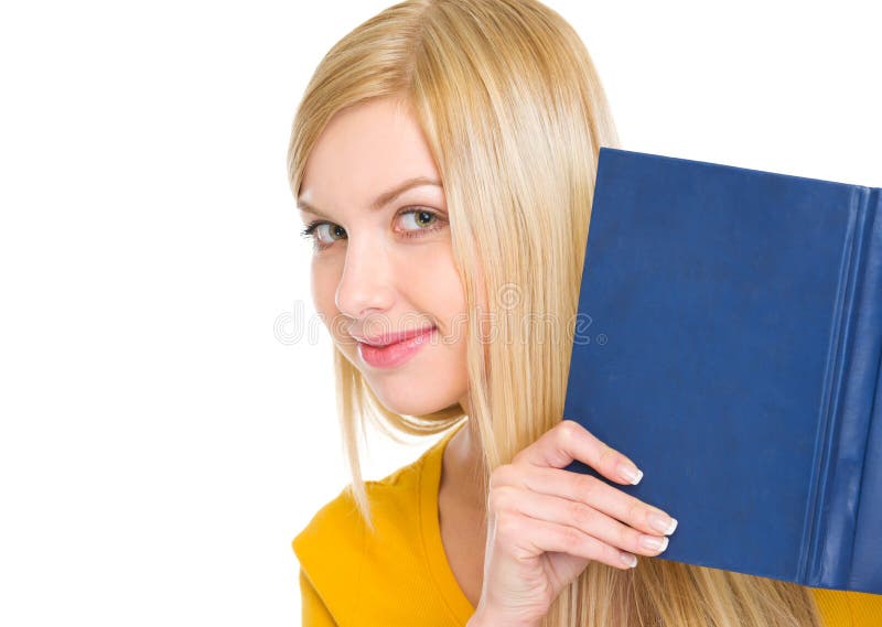 Happy student girl looking out from book