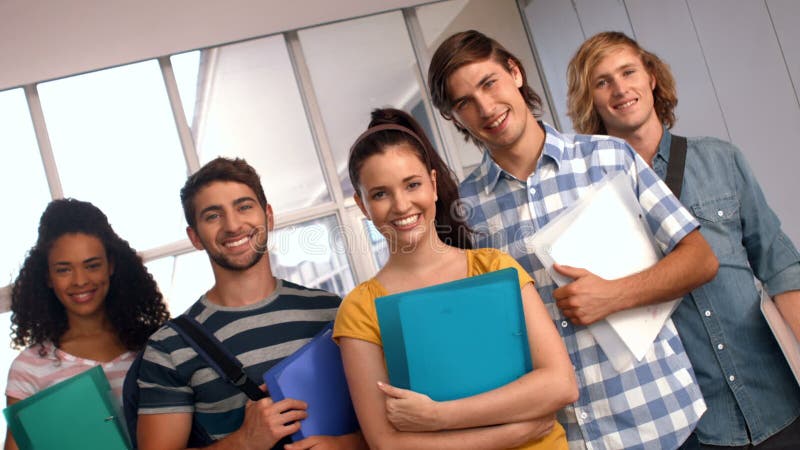 Happy students looking at camera with thumbs up at the university