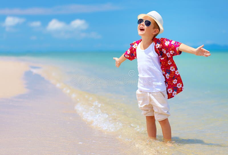 Happy stylish boy enjoys life on summer beach