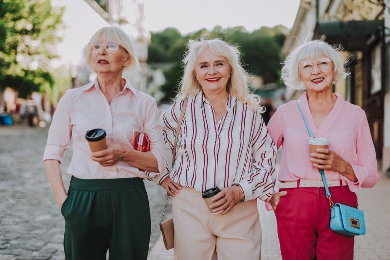 Waist up portrait of three beautiful older women having fun together while ...