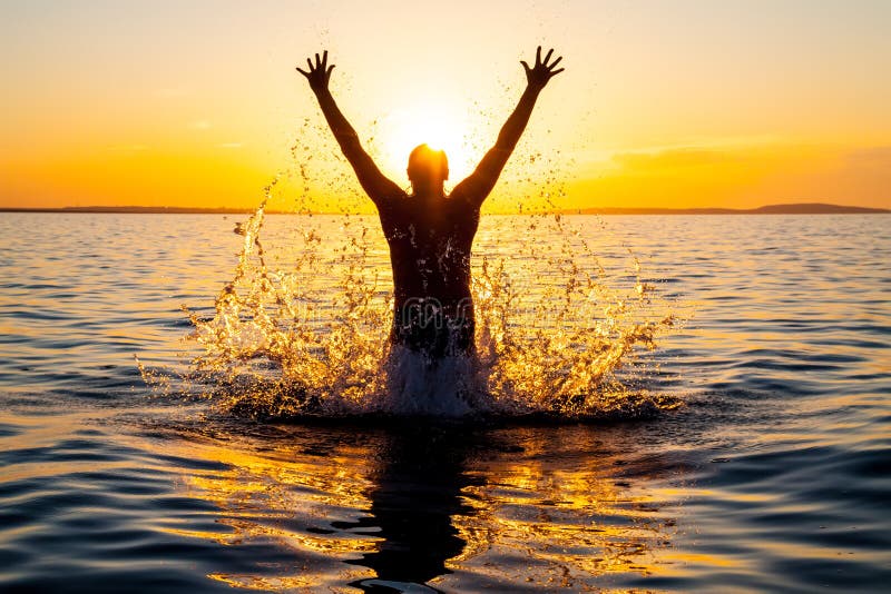 Swimmer jumping out of sea water at warm sunrise. Swimmer jumping out of sea water at warm sunrise