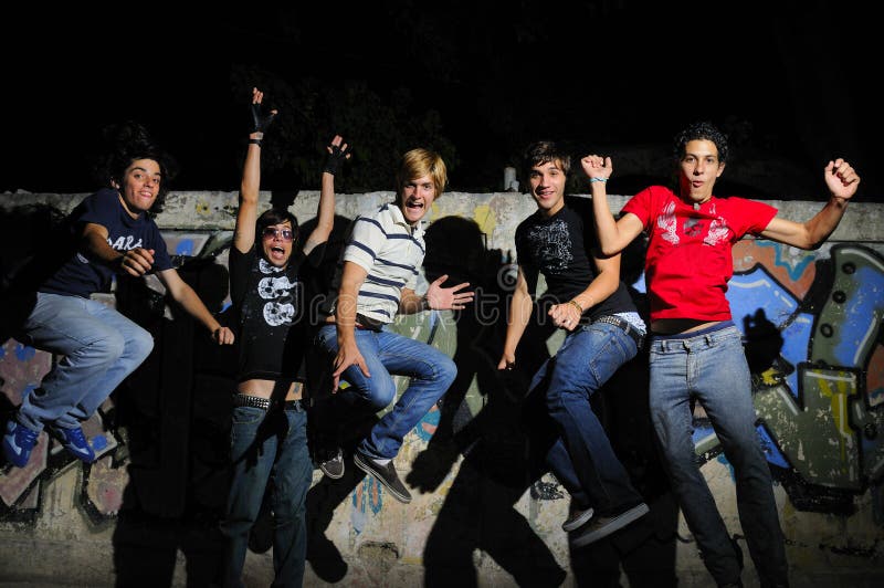 Team di 5 adolescenti alla moda di saltare di felicità.