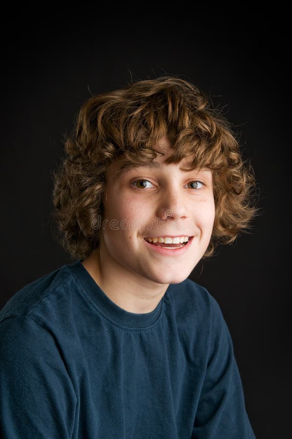 Closeup of a happy teen boy shot in studio on a black background