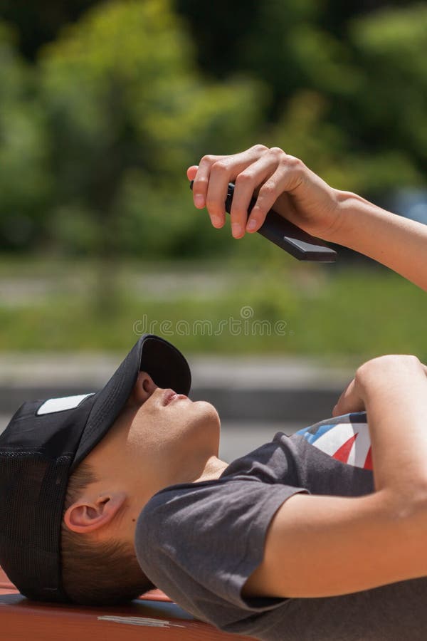 Happy teen boy on the street and using smart phone stock photo Happy teen boy on the street and using smart phone stock photo