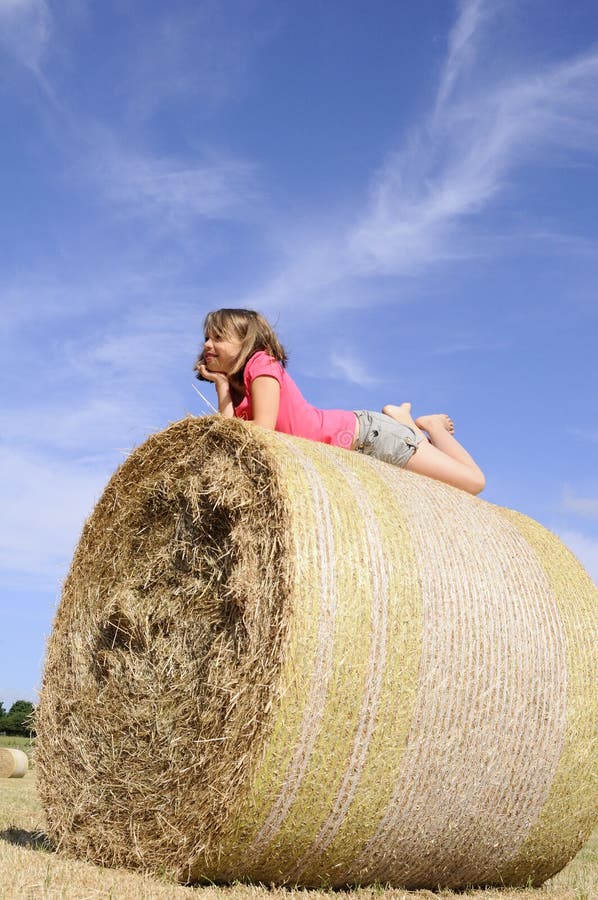 Happy teen having fun on hay bales