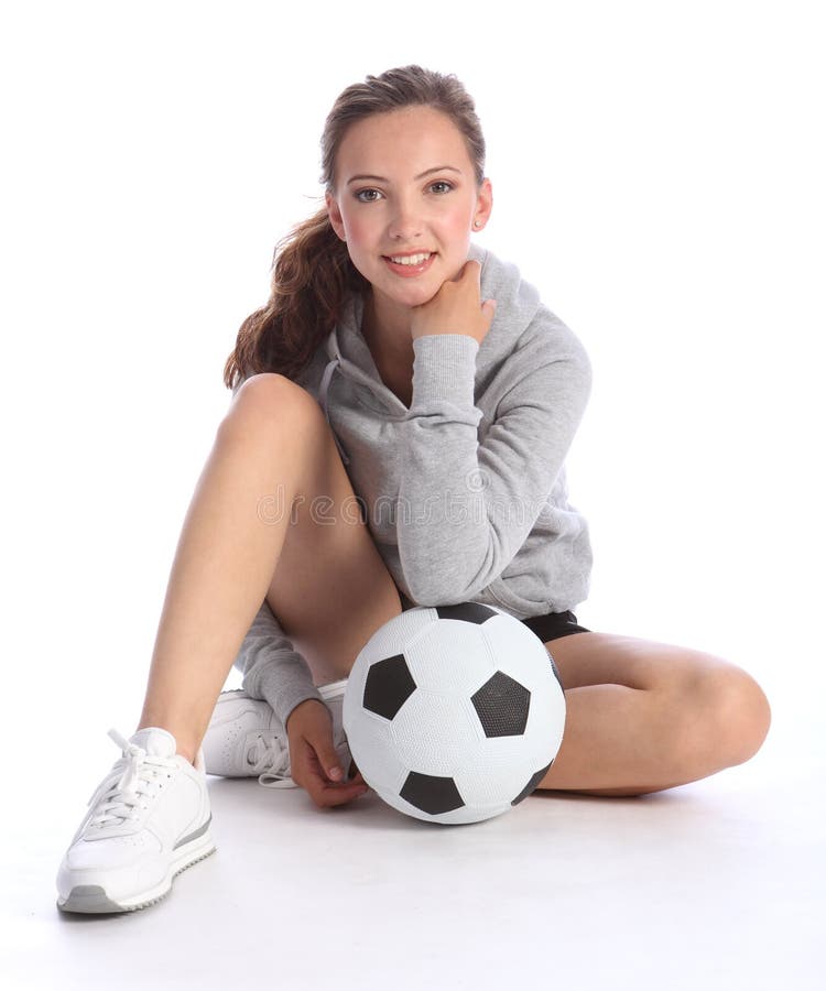 Happy teenage girl football player sits with ball